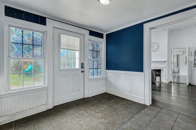 doorway to outside featuring a wainscoted wall and a wealth of natural light