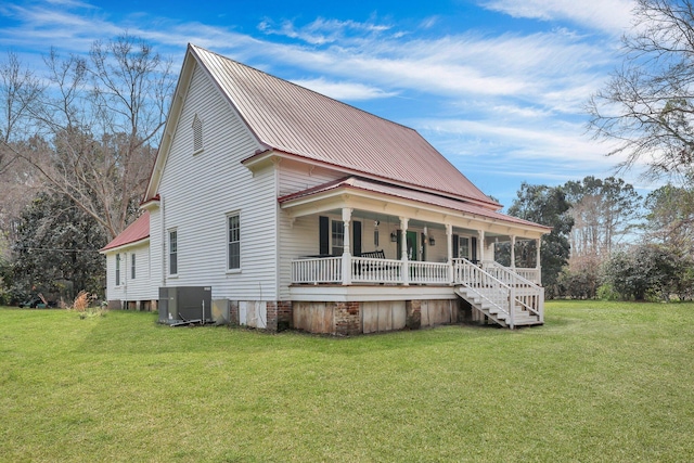 view of front facade featuring metal roof, central AC, a front lawn, and a porch