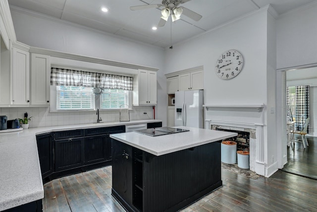 kitchen featuring a ceiling fan, tasteful backsplash, white refrigerator with ice dispenser, dark cabinetry, and black electric cooktop