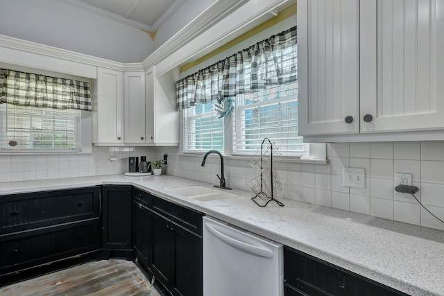 kitchen featuring white dishwasher, a sink, white cabinetry, crown molding, and dark cabinets