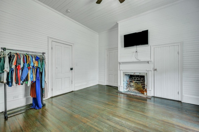 living room featuring ceiling fan, wood-type flooring, a fireplace with raised hearth, and crown molding