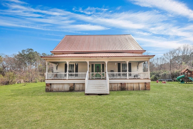 rear view of house with metal roof, a yard, and a porch