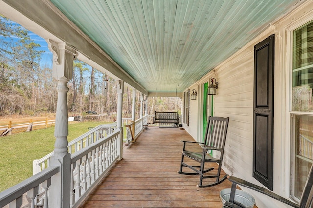 deck featuring a yard and covered porch