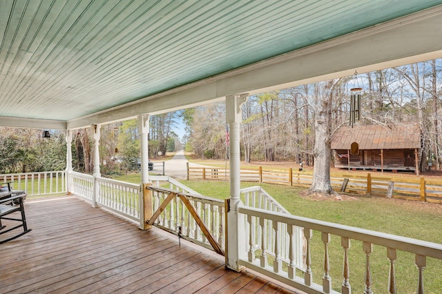 wooden terrace with a yard and fence