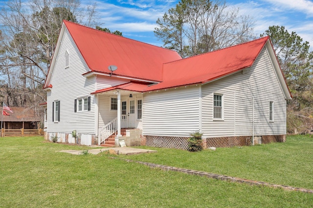 back of house featuring entry steps, a yard, fence, and metal roof