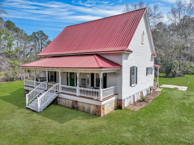 view of front of home featuring a front lawn, covered porch, and metal roof