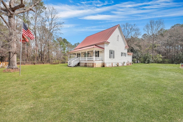 exterior space with metal roof, a lawn, and a porch