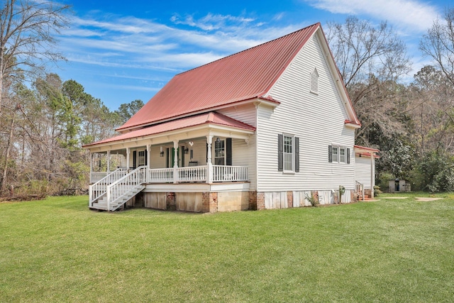 view of front of house featuring a porch, metal roof, and a front yard