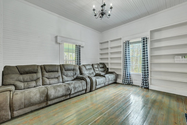 living area featuring built in features, crown molding, an inviting chandelier, and hardwood / wood-style floors