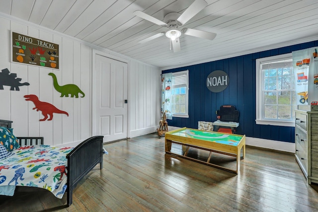 bedroom featuring multiple windows, baseboards, and wood-type flooring