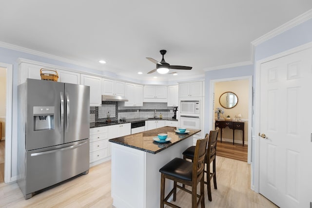 9091 Delancey Cir N, Charleston, SC 29406 - kitchen featuring white appliances, a ceiling fan, white cabinets, a kitchen breakfast bar, and tasteful backsplash