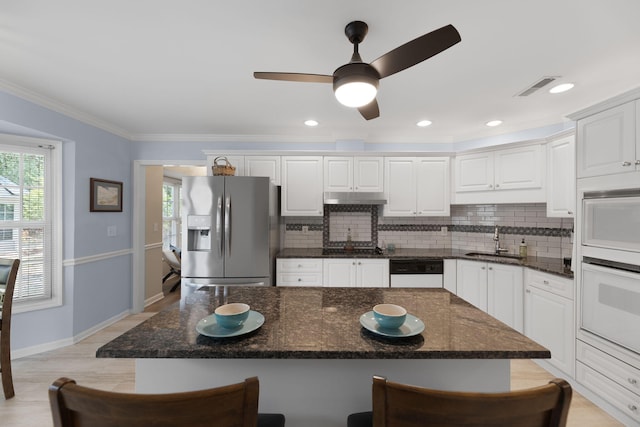 9091 Delancey Cir N, Charleston, SC 29406 - kitchen with white appliances, decorative backsplash, a breakfast bar area, under cabinet range hood, and white cabinets