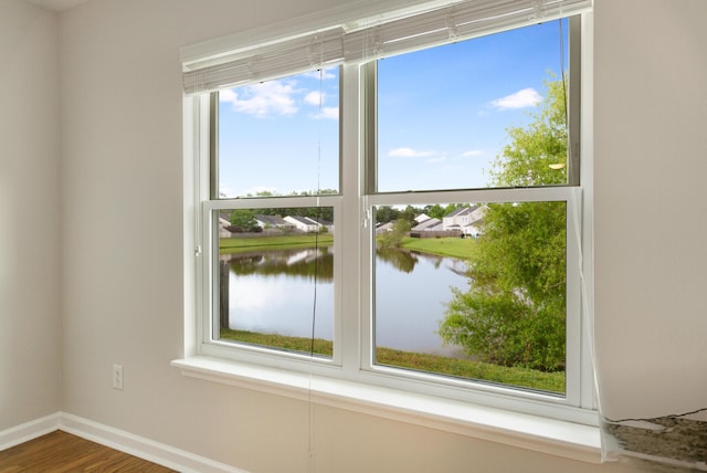 room details with a water view, baseboards, and wood finished floors