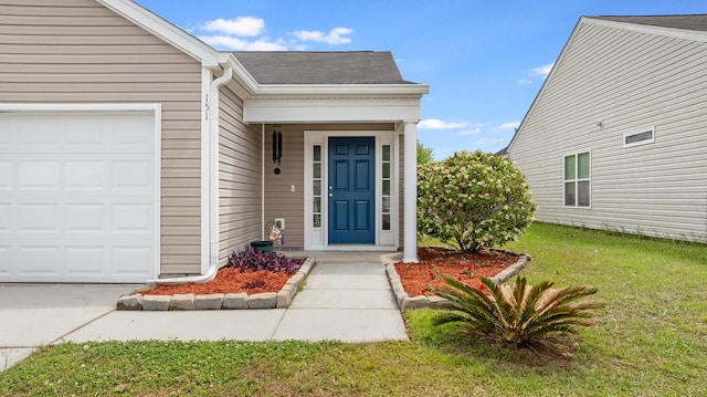 entrance to property featuring a yard, an attached garage, and roof with shingles