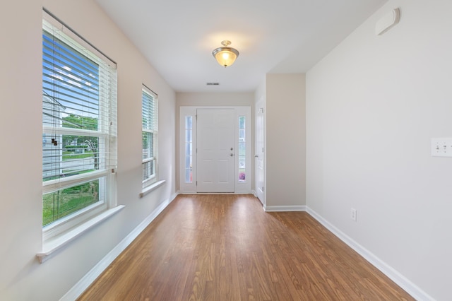 entrance foyer featuring baseboards, wood finished floors, and visible vents