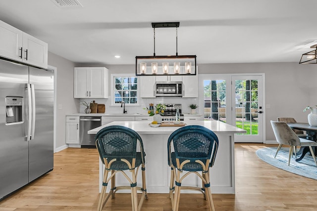 1391 Fairfield Ave, Charleston, SC 29407 - kitchen featuring appliances with stainless steel finishes, light countertops, a sink, white cabinetry, and a kitchen island