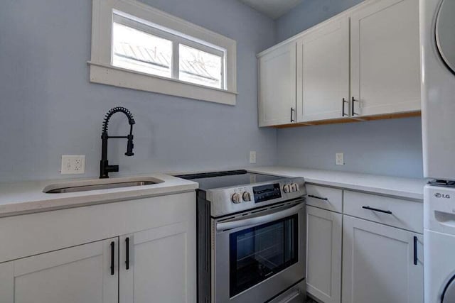 kitchen featuring stainless steel range with electric cooktop, white cabinets, sink, and white fridge