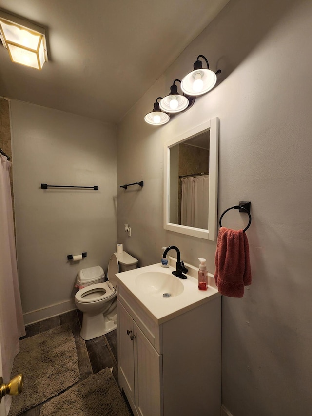 bathroom featuring walk in shower, hardwood / wood-style floors, vanity, and toilet