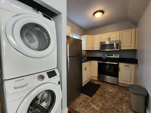 kitchen with stainless steel appliances, stacked washing maching and dryer, and lofted ceiling