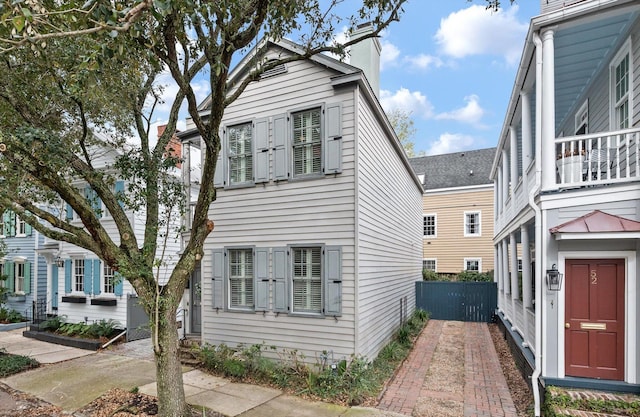 view of property exterior with fence and a chimney