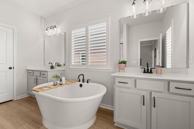 226 Midtown Ave, Summerville, SC 29486 - full bath featuring wood finished floors, a freestanding bath, two vanities, and baseboards