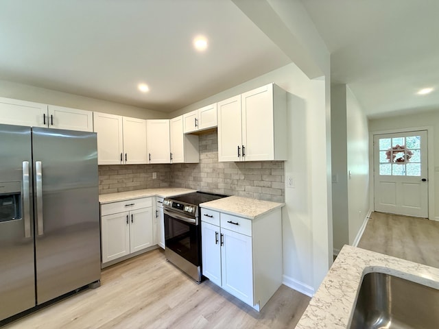 6086 Chisolm Rd, Johns Island, SC 29455 - kitchen with light wood-style floors, appliances with stainless steel finishes, backsplash, and white cabinetry