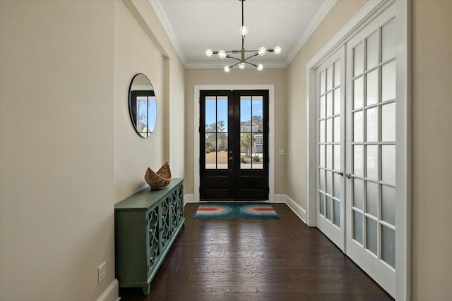 foyer featuring dark wood-style floors, baseboards, french doors, crown molding, and a chandelier