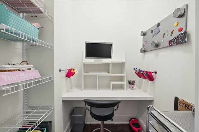 home office featuring built in study area and baseboards