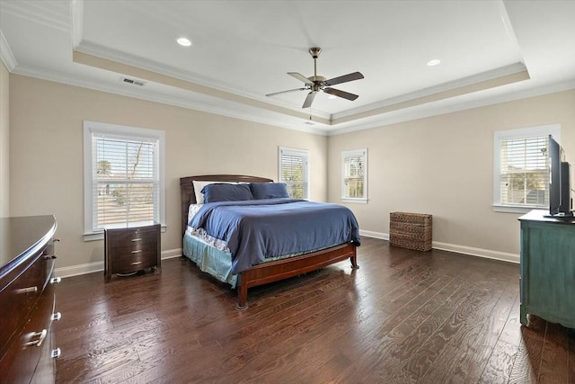 bedroom featuring multiple windows, a tray ceiling, and dark wood-style flooring