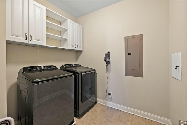 washroom featuring baseboards, electric panel, light tile patterned floors, cabinet space, and washer and dryer