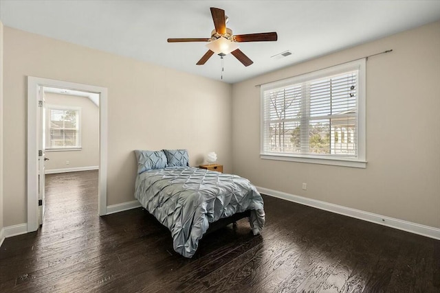 bedroom featuring visible vents, baseboards, and wood finished floors