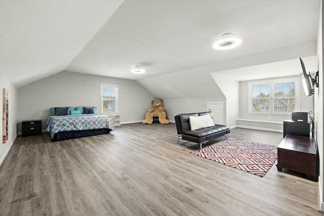 bedroom featuring baseboards, lofted ceiling, and wood finished floors