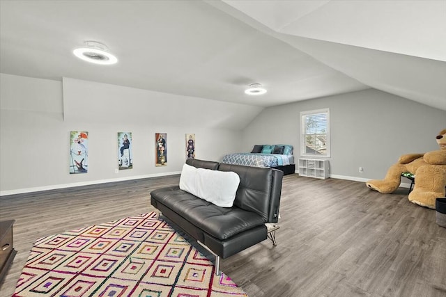 bedroom featuring lofted ceiling, wood finished floors, and baseboards