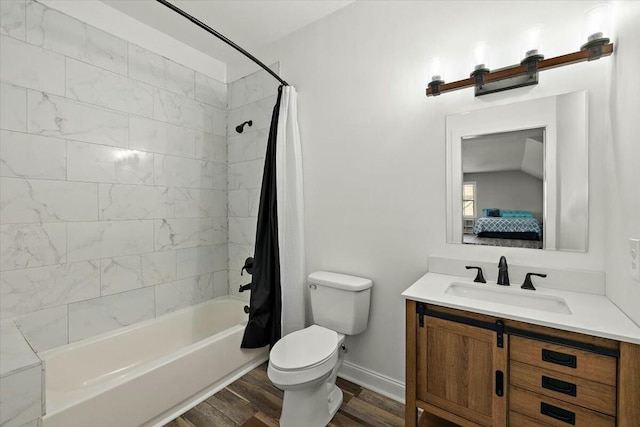 bathroom featuring toilet, wood finished floors, shower / tub combo, baseboards, and vanity