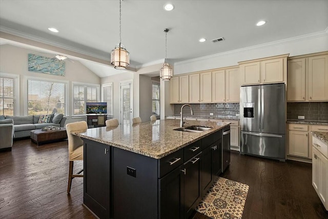 kitchen with visible vents, open floor plan, a breakfast bar, stainless steel appliances, and a sink