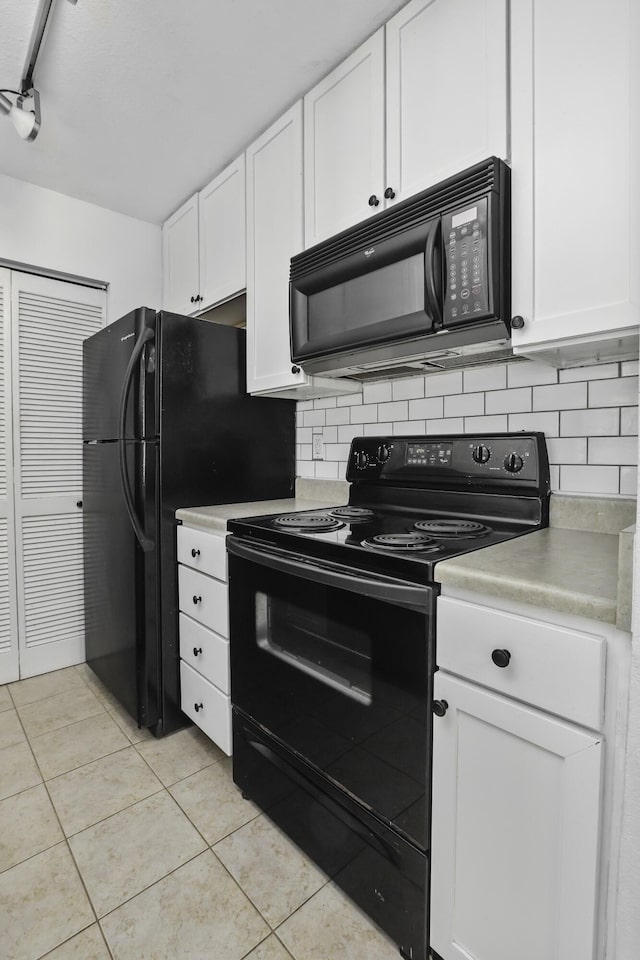 kitchen with light tile patterned flooring, white cabinetry, tasteful backsplash, track lighting, and black appliances