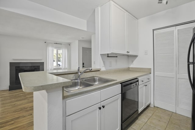 kitchen featuring light tile patterned flooring, sink, white cabinetry, dishwasher, and kitchen peninsula