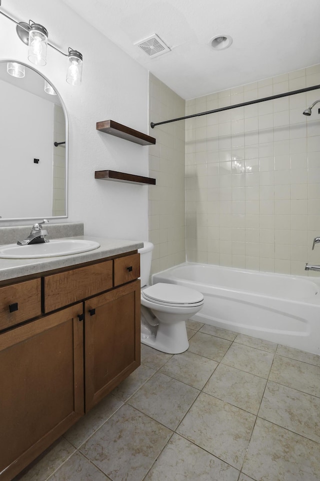 full bathroom with tiled shower / bath, vanity, toilet, and tile patterned floors