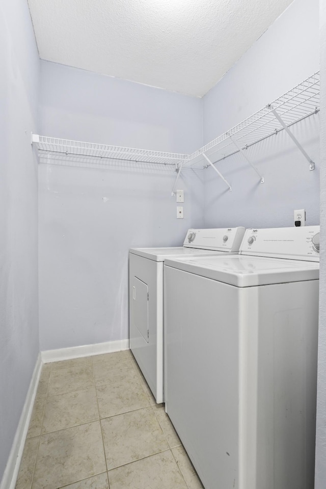 washroom with light tile patterned flooring and washer and clothes dryer