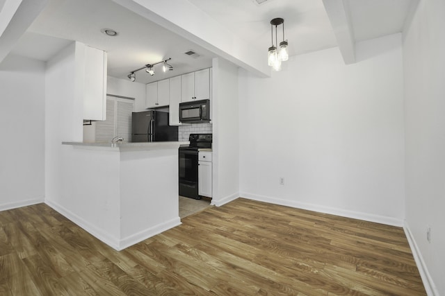 kitchen featuring black appliances, kitchen peninsula, hardwood / wood-style flooring, decorative backsplash, and white cabinets