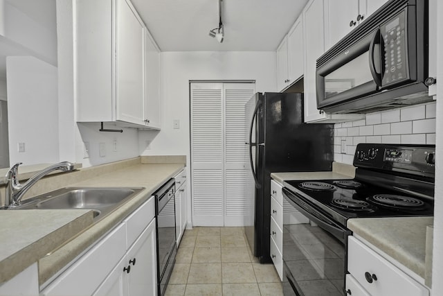 kitchen with light tile patterned flooring, white cabinetry, sink, black appliances, and track lighting