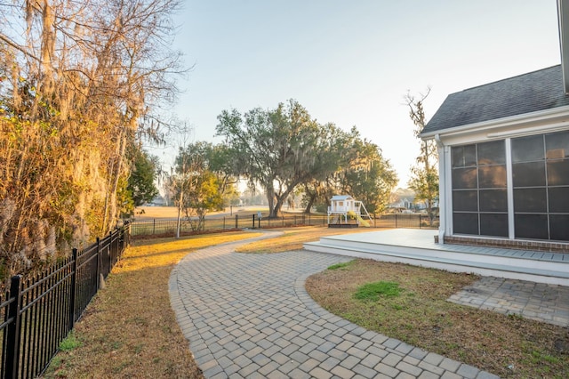 view of property's community with a playground, a patio area, and fence