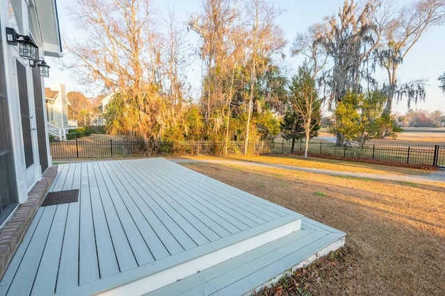 wooden terrace featuring a fenced backyard and a lawn