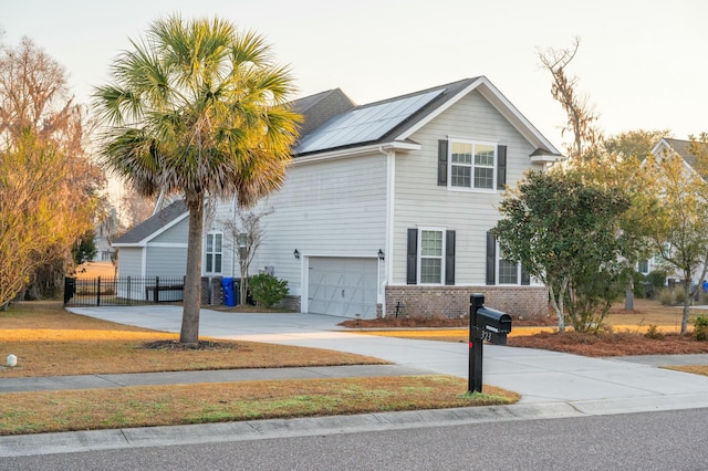 traditional-style home with a garage, concrete driveway, brick siding, and fence