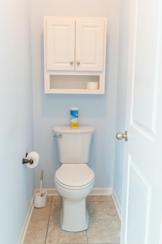 bathroom featuring toilet, tile patterned flooring, and baseboards