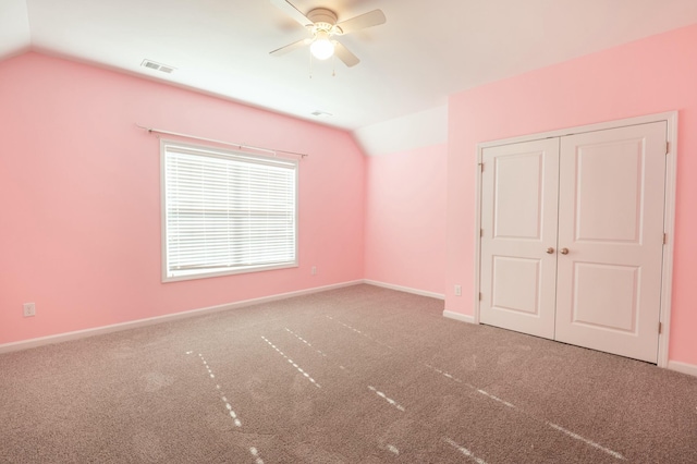 unfurnished bedroom with lofted ceiling, baseboards, visible vents, and carpet flooring