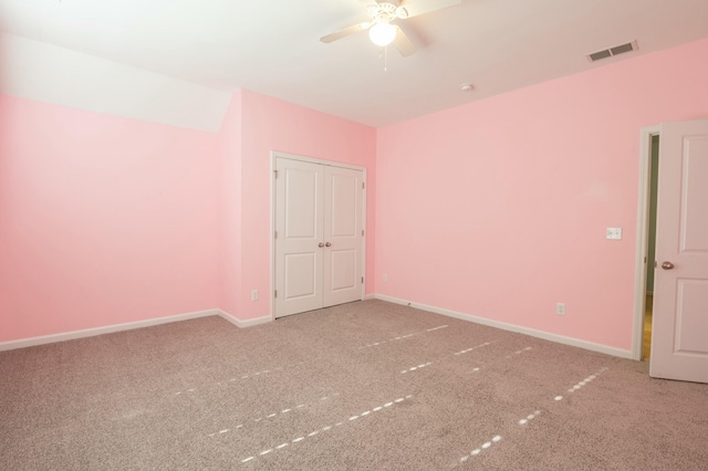 carpeted empty room featuring a ceiling fan, visible vents, and baseboards