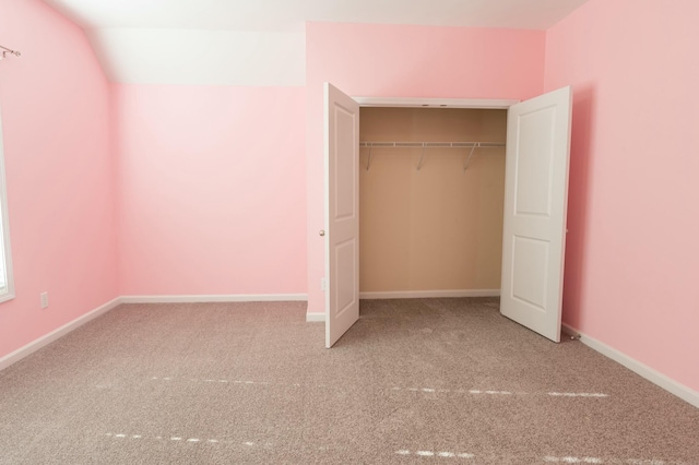 unfurnished bedroom with a closet, carpet flooring, and baseboards