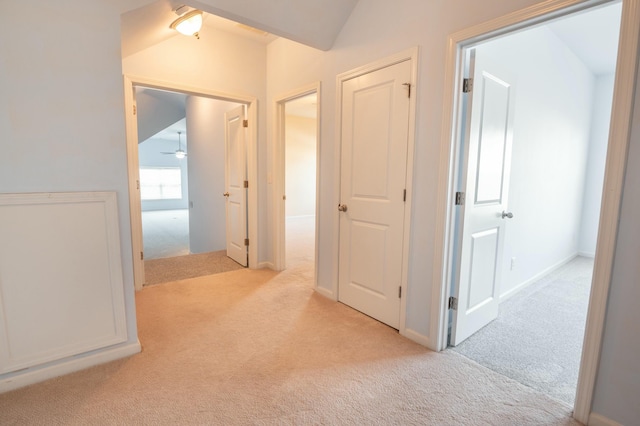 corridor with lofted ceiling and light carpet