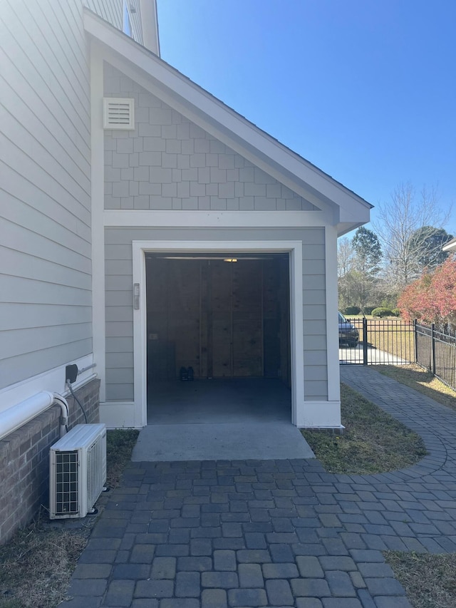 garage featuring fence and decorative driveway